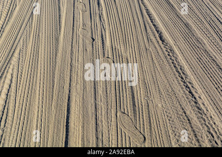 Impronte e tracce di pneumatici nella sabbia Foto Stock