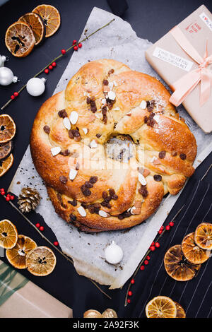 Appena sfornato rotolo chrismtas corona su un sfondo di legno con varie decorazioni natalizie Foto Stock