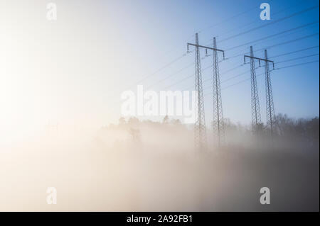 Tralicci di energia elettrica in caso di nebbia Foto Stock