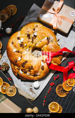 Appena sfornato rotolo chrismtas corona su un sfondo di legno con varie decorazioni natalizie Foto Stock