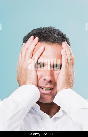 Primo piano di un uomo medio adulto che soffre di mal di testa Foto Stock