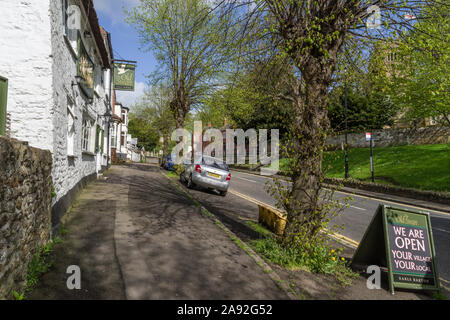 Street view in primavera, Earls Barton village, Northamptonshire, Regno Unito; l'Old Swan pub a sinistra Foto Stock
