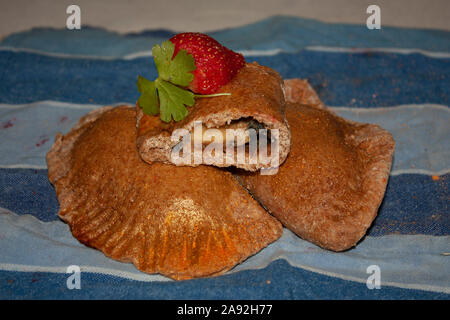 Integrale di fresco e sano dolce empanadas ripiene di color oro, confettura di fragole cibo gourmet Foto Stock