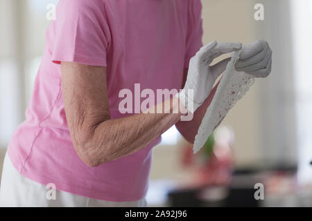 Donna anziana che si prepara per un pranzo Foto Stock