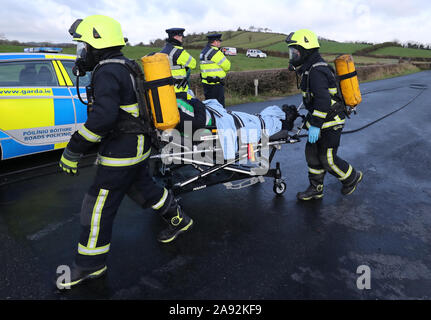 Fire equipaggi provenienti da Irlanda del Nord e della Repubblica di Irlanda il recupero di un ferito da una simulazione di crash che coinvolgono un combustibile di autocarri e di autobus, durante un multi-agenzia esercizio di emergenza in Castleblayney, nella contea di Monaghan, Irlanda. Foto Stock