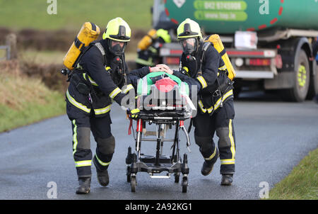 Fire equipaggi provenienti da Irlanda del Nord e della Repubblica di Irlanda il recupero di un ferito da una simulazione di crash che coinvolgono un combustibile di autocarri e di autobus, durante un multi-agenzia esercizio di emergenza in Castleblayney, nella contea di Monaghan, Irlanda. Foto Stock