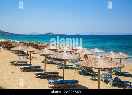 Resort con sedie e rifugio lungo la spiaggia di Plaka sul Mar Mediterraneo; Naxos Isola, Cicladi, Grecia Foto Stock