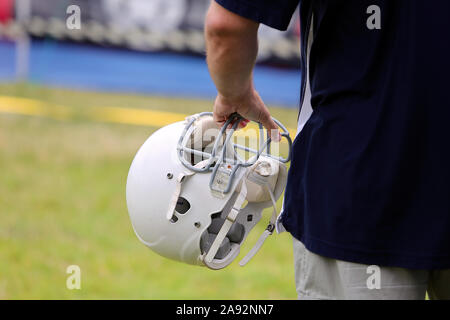 Giocatore di Rugby tenendo un casco in mani e va al campo sportivo Foto Stock