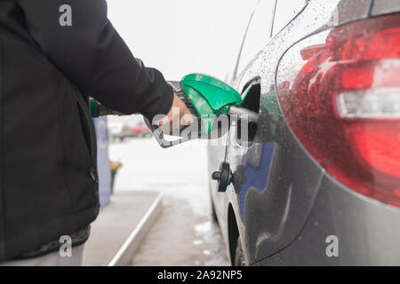 Mano azienda ugello carburante in auto Foto Stock