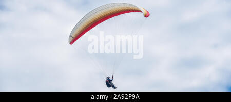 Uomo a volare su un aquilone paracadute su sfondo cielo Foto Stock