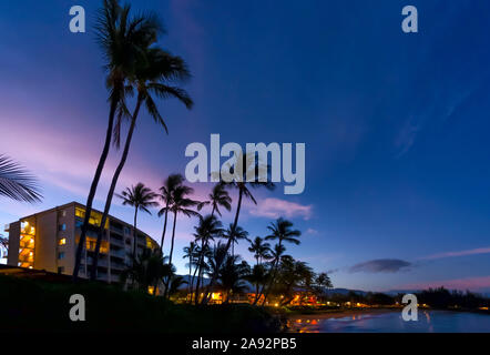 Hotel e palme lungo la costa al tramonto, Kamaole una e due spiagge, Kamaole Beach Park; Kihei, Maui, Hawaii, Stati Uniti d'America Foto Stock