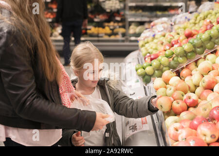 Madre e figlia scegliendo le mele nel supermercato Foto Stock