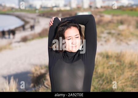 Surfista femmina stretching Foto Stock