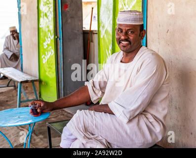 Uomo sudanese che beve tè in un ristorante; Abri, Stato del Nord, Sudan Foto Stock