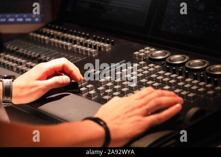 L'operatore lavora con illuminazione del palcoscenico della console di comando. Messa a fuoco selettiva. Foto Stock