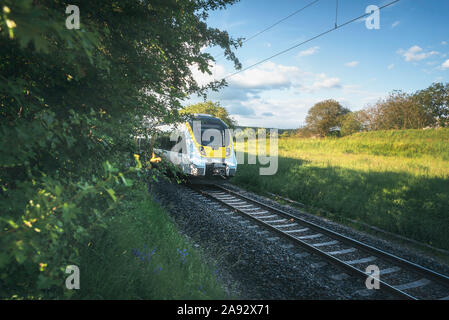 Ad alta velocità ferroviaria tedesca che viaggiano attraverso la natura verdeggiante paesaggio sulla giornata di sole. Il treno attraversa paesaggi di campagna vicino a Schwabisch Hall, Germania Foto Stock