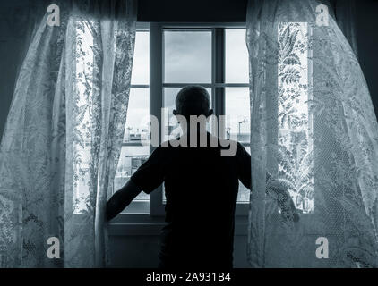 Vista posteriore dell'uomo guardando fuori della finestra. Concetto di immagine per la depressione, depressione maschio, salute mentale, maschio suicida... Foto Stock