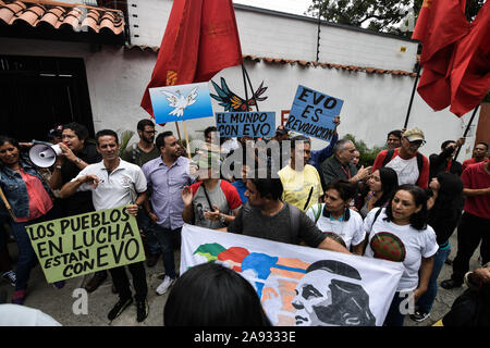 La folla di tifosi con cartelli e bandiere presso l ambasciata Boliviana durante la protesta.i sostenitori dei movimenti sociali e il venezuelano della gioventù comunista protesta a sostegno dell ex presidente Evo Morales di fronte all'ambasciata boliviana. Il presidente del paese si è dimesso dopo una forte protesta contro la sua rielezione e per aver rifiutato di condurre una verifica dei voti. Foto Stock