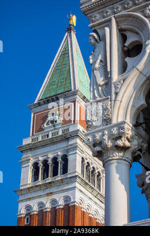 Una vista dell'iconica Piazza San Marco il campanile con un dettaglio della parte esterna del Palazzo Ducale o Palazzo dei Dogi in primo piano, a Venezia, Italia. Foto Stock