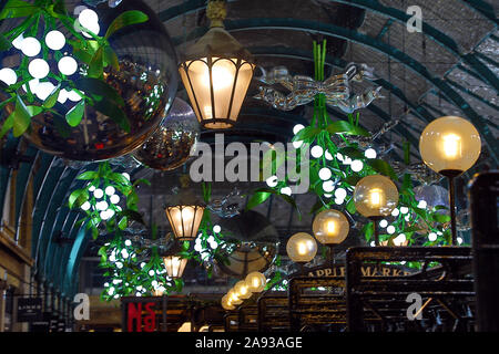 Londra, Regno Unito. 12 novembre 2019. Mercato di Covent Garden Natale luci accese, Covent Garden di Londra con il vischio tradizionale e albero di Natale design baubles Credito: Paul Brown/Alamy Live News Foto Stock