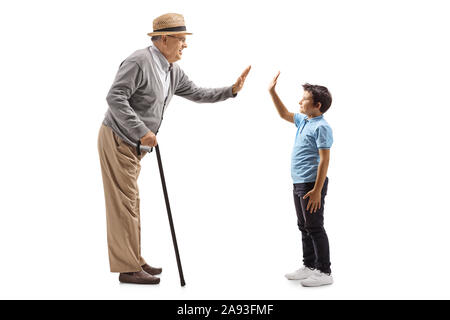 Lunghezza piena ripresa del profilo di un nipote e nonno gesticolando alta cinque isolati su sfondo bianco Foto Stock