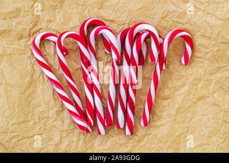 Un sacco di caramella dolce candy canes su un accartocciata carta pergamena. Gustosa attributo decorativo del Natale e del nuovo anno. Vista dall'alto. Foto Stock