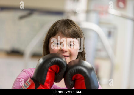 Ritratto di una donna con sindrome di Down che lavora con guanti da boxe Foto Stock