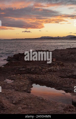 Pozze di mare sulla spiaggia al tramonto Foto Stock