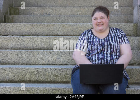 Donna con problemi di vista che utilizza il suo computer Foto Stock