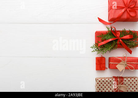 Composizione di Natale fatto di rosso, verde, marrone predisposto i regali di Natale in legno bianco sullo sfondo della tabella. Natale, Natale, inverno, anno nuovo concetto Foto Stock