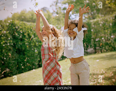 Due sorelle sorridenti e danzanti nel loro cortile posteriore Foto Stock