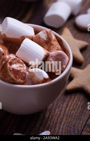 Cioccolata calda, cacao con marshmallows, forma a stella e forma di cuore biscotti di Natale sulla festosa tavola in legno rustico, vista dall'alto Foto Stock