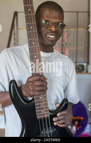 Giovane con la sindrome di Williams che suona la sua chitarra elettrica Foto Stock