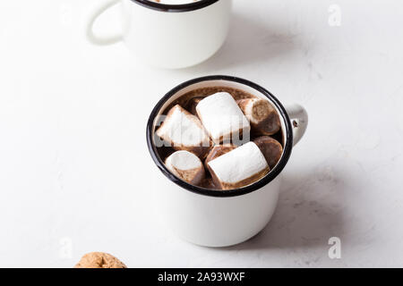 Hot Chocolate, Cocoa sulla festosa tavolo bianco, tradizionale autunno e inverno bevanda calda con marshmallow in bianco tazze, close up Foto Stock