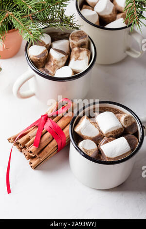 Hot Chocolate, Cocoa sulla festosa tavolo bianco, tradizionale autunno e inverno bevanda calda con marshmallow in bianco tazze, close up Foto Stock