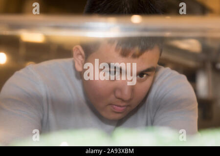 Giovane con autismo che lavora in un ristorante Foto Stock