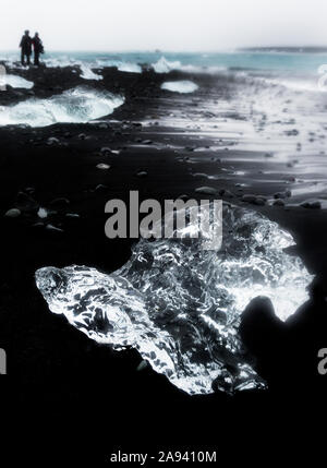 Luccicante pezzi di ghiaccio lavare fino su un flusso di lava che spiaggia di sabbia nera nel Nord Atlantico, dando l'aspetto di diamanti sulla spiaggia a Jokulsarlon glaci Foto Stock