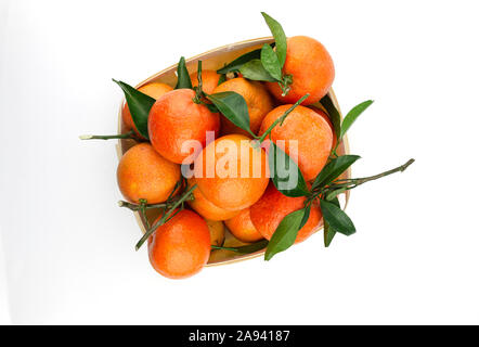 Extra dolce e succosa clementine spagnole con foglie in una cesta. Isolato su bianco. Vista dall'alto in basso. Foto Stock