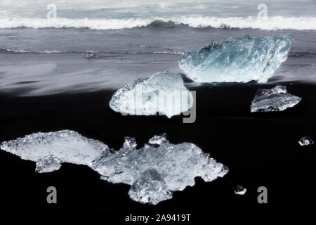 Luccicante pezzi di ghiaccio lavare fino su un flusso di lava che spiaggia di sabbia nera nel Nord Atlantico, dando l'aspetto di diamanti sulla spiaggia a Jokulsarlon glaci Foto Stock