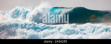 Le onde tropicali dell'oceano si infrangono e si spruzzi al largo della costa di Na Pali; Kauai, Hawaii, Stati Uniti d'America Foto Stock