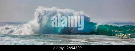 Le onde tropicali dell'oceano si infrangono e si spruzzi al largo della costa di Na Pali; Kauai, Hawaii, Stati Uniti d'America Foto Stock