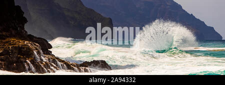 Le onde tropicali dell'oceano si infrangono e si spruzzi, Na Pali Coast; Kauai, Hawaii, Stati Uniti d'America Foto Stock