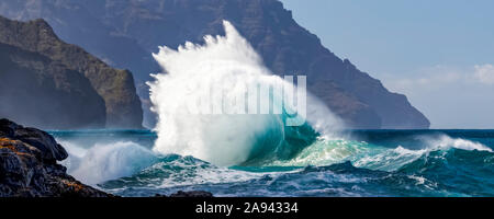 Le onde tropicali dell'oceano si infrangono e si spruzzi, Na Pali Coast; Kauai, Hawaii, Stati Uniti d'America Foto Stock