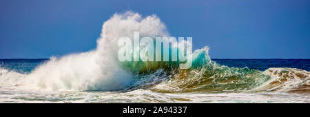 Le onde tropicali dell'oceano si infrangono e si spruzzi, Na Pali Coast; Kauai, Hawaii, Stati Uniti d'America Foto Stock