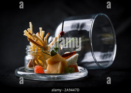 Formaggi assortiti con frutti di bosco e confettura, mini servire in un pallone di vetro. Cucina di fusione concetto chiave di basso, spazio di copia Foto Stock