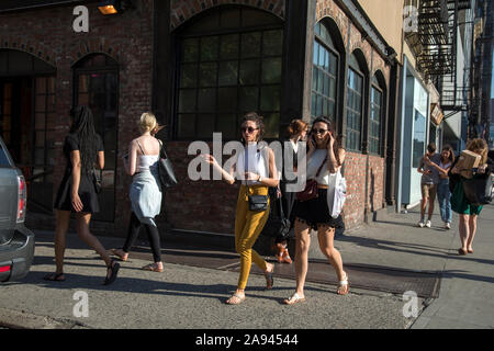 Le giovani donne a piedi sul marciapiede di New York Bowery, Mnahattan inferiore. Foto Stock