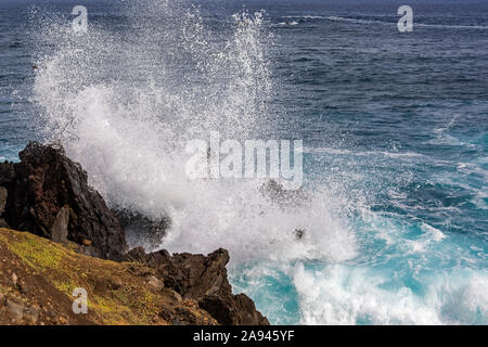 Grande onda che si schiantano contro le rocce vulcaniche; Isola di Pasqua, Cile Foto Stock