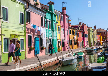 Burano, Italia - 19 Luglio 2019: una strada di bella multi-colore di case tradizionali lungo un canale sulla isola veneziana di Burano nel nord Ita Foto Stock