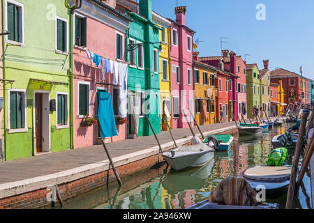 Burano, Italia - 19 Luglio 2019: una strada di bella multi-colore di case tradizionali lungo un canale sulla isola veneziana di Burano nel nord Ita Foto Stock