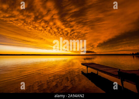 Tramonto dorato luminoso su un lago, Meadow Lake Provincial Park; Saskatchewan, Canada Foto Stock